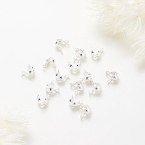 Close-up of polished silver metal fold-over cord ends and shell clamps for DIY jewelry making