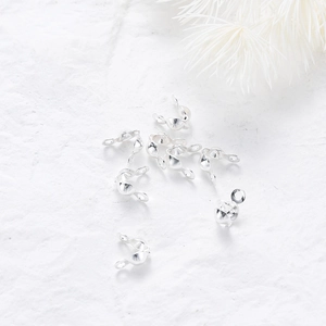 Macro shot of silver calotte ends and bead tip covers for DIY jewelry making on stone surface