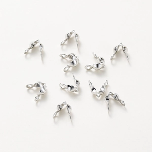 Close-up of bright silver clam shell bead tips for DIY jewelry making and connection