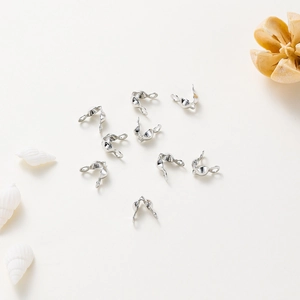 Macro view of silver-plated bead tip clam shell connectors for DIY jewelry making