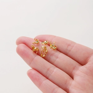 Hand holding 18k rose gold plated double bead connectors for DIY jewelry making