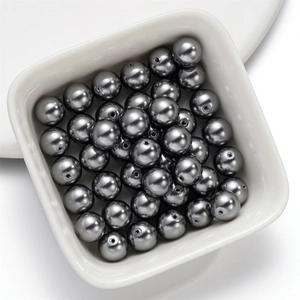 Glossy silver-grey glass pearl beads in a white bowl for DIY necklace jewelry making