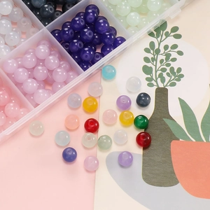 Detailansicht bunter Glasperlen und DIY-Schmuckset in einer transparenten Box