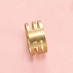 Makroaufnahme des breiten Goldrings mit dreilagigem Design und mattem Finish