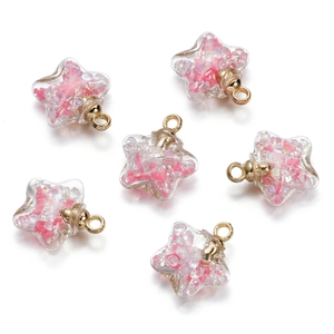 Detail view of six star-shaped glass pendants with pink glitter and gold metal rings