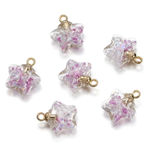 Detail of star-shaped glass charms with purple glitter and golden metal loops