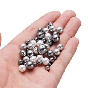 Close-up of mixed sizes high-luster glass pearls held in hand for jewelry DIY