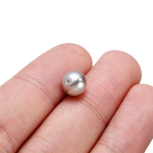 Macro shot of a silver metallic pearl bead with hole detail for DIY jewelry making