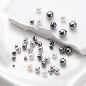 Macro detail of mixed size glass pearl beads in white and grey for DIY jewelry making