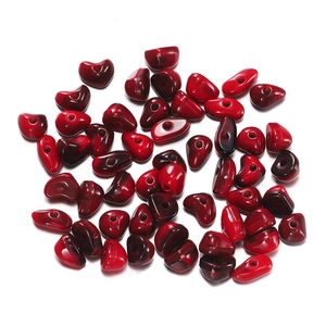 Macro shot of irregular red acrylic beads with gradient finish for DIY jewelry