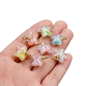 Close-up of colorful luminous star glass pendants with golden rings for DIY jewelry making