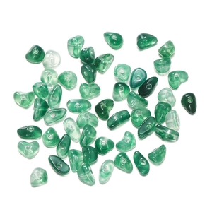Macro shot of irregular green agate-textured glass beads with pre-drilled holes for DIY jewelry