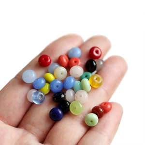 Close-up of colorful round abacus glass beads held in hand for DIY jewelry making