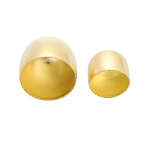 Nahaufnahme von kleinen und großen polierten goldenen Metallkappen für Windspiele