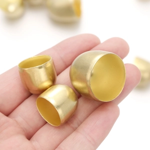 Drei Größen matter goldener Glockenkappen aus Metall für DIY-Schmuck in einer Hand gehalten