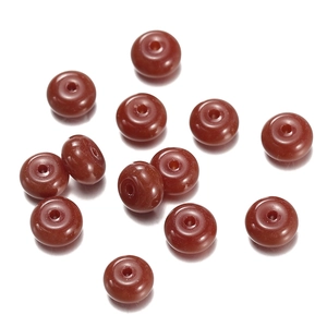 Macro detail of eleven dark red flat rondelle beads for DIY jewelry making and crafts