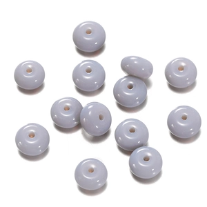 Macro view of pastel purple flat round glass beads for DIY jewelry and handmade crafts