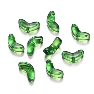 Macro shot of transparent emerald green curved beads with holes for DIY craft jewelry