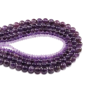 Macro view of assorted natural amethyst round beads with textures and varying purple shades