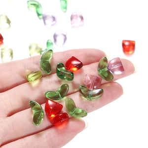 Close-up of colorful heart and leaf shaped tulip beads for DIY jewelry making held in hand