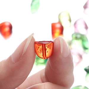 Macro shot of an orange tulip-shaped acrylic bead for DIY jewelry making
