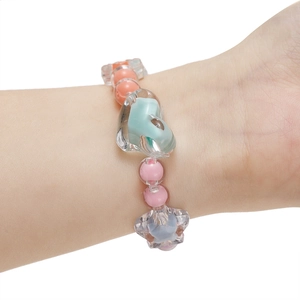 Detailopname van een kleurrijke Y2K kralenarmband met hart- en sterbedeltjes van hars