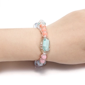 Detail van kleurrijke acryl kralenarmband om de pols met doorschijnende kralen