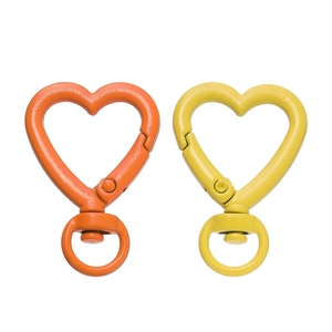 Vista macro dettagliata dei moschettoni a molla a forma di cuore arancio e giallo per fai da te