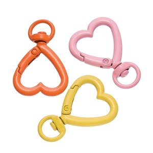 Dettaglio di moschettoni a cuore da 26mm in arancione, rosa e giallo con finitura opaca