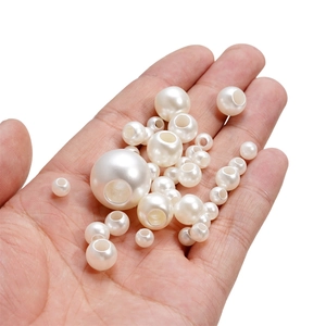 Vue détaillée de perles en ABS blanc crème avec trous pour la création de bijoux DIY