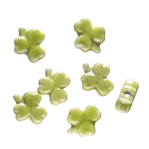 Detailed view of light green clover-shaped ceramic beads for DIY jewelry making