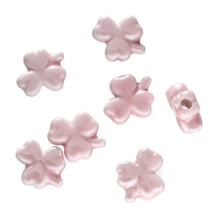 Macro shot of pink clover glazed ceramic beads with side holes for DIY jewelry