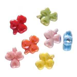 Macro detail of colorful glazed ceramic clover beads with side holes for DIY jewelry