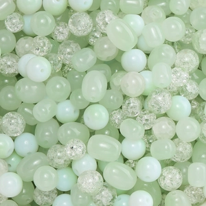 Gros plan de perles de verre craquelé vert clair en formes variées pour création de bijoux