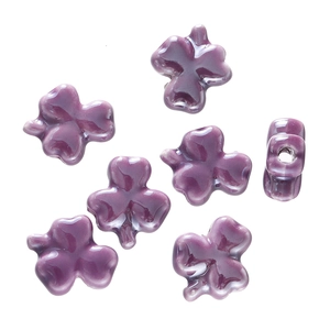 Macro detail of deep purple clover ceramic beads with smooth glaze finish and center holes
