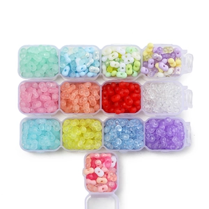 Close-up of colorful 4mm peanut-shaped acrylic beads in a plastic storage organizer box