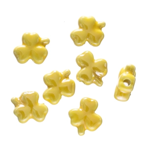 Macro detail of yellow clover ceramic beads showing high-gloss glaze and side hole for DIY