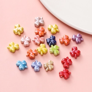 Flat lay of colorful glazed ceramic clover beads for DIY jewelry and bracelets