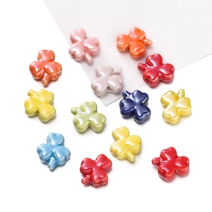 Macro view of colorful clover ceramic beads with smooth glaze and pre-drilled holes