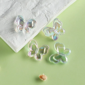 Close-up of four iridescent 22mm acrylic butterfly beads for DIY jewelry making