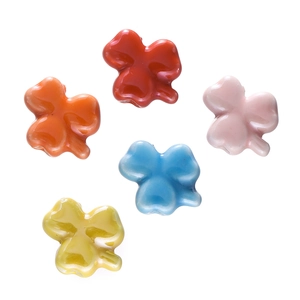 Detail showing five colorful clover-shaped ceramic beads for DIY jewelry making