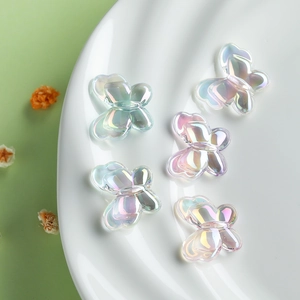 Macro view of 22mm iridescent butterfly beads on a decorative white ceramic plate
