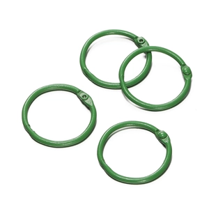 Détail de quatre anneaux de reliure en métal peint en vert de 30 mm pour le DIY