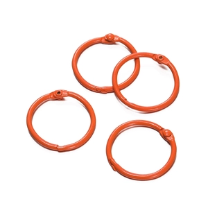 Détail de quatre anneaux de reliure en métal orange pour le bricolage et le reliage