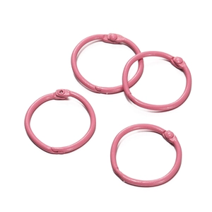 Gros plan de quatre anneaux de reliure en métal rose mat pour papeterie créative DIY