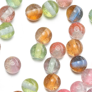 Macro shot of 10mm resin beads with silver glitter and colorful ribbons for DIY jewelry
