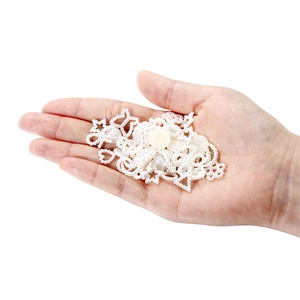 Sortierte weiße Perlenanhänger in Stern-, Herz- und Schmetterlingsform in der Hand gehalten