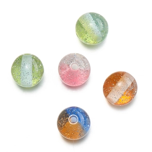 Macro detail of 10mm glitter resin beads with dual-tone designs for DIY jewelry making