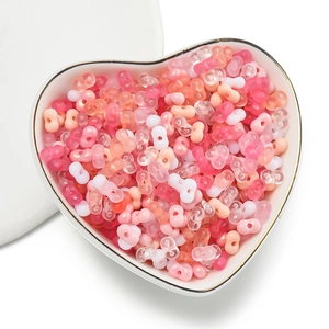 Detailed view of pink and white peanut-shaped acrylic beads in a heart-shaped bowl