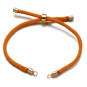 Detail van verstelbare oranje gevlochten koordarmband met gouden schuifjes en ringen